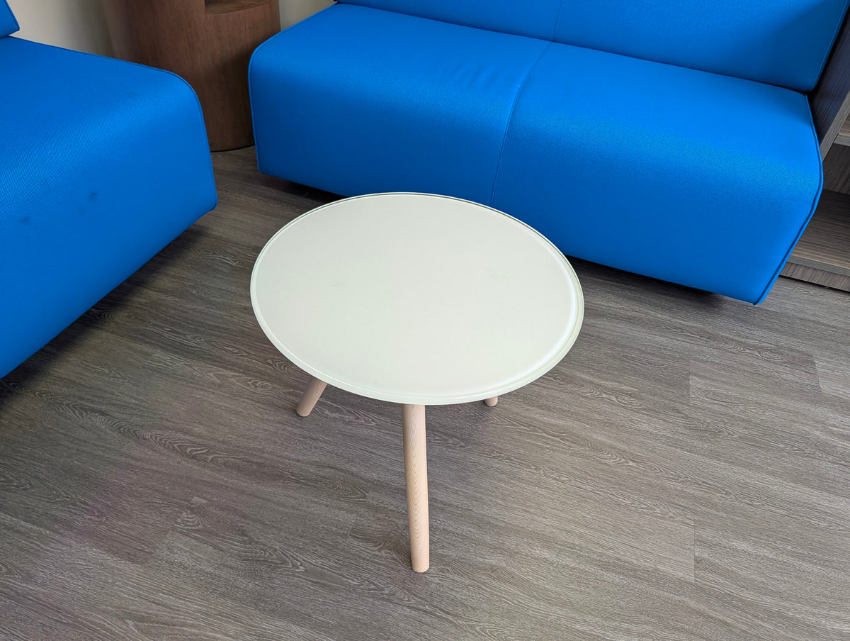Round white glass-top side table with wood tripod legs